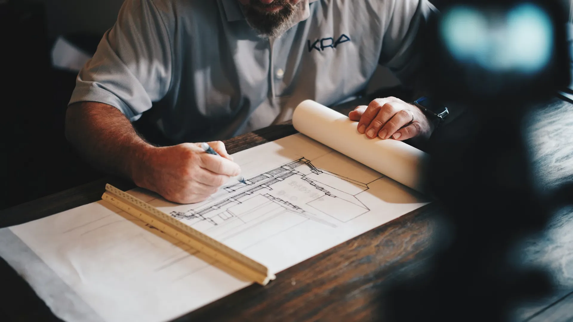 Architecte traçant des plans techniques sur table en bois